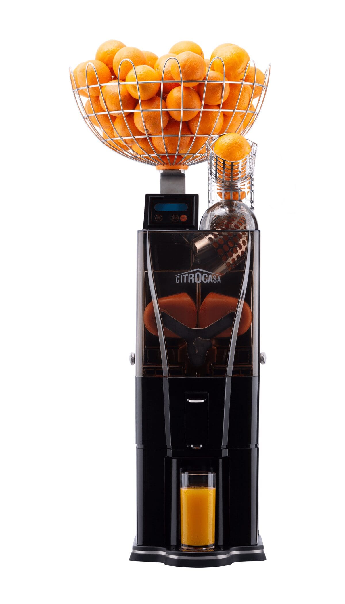 A commercial juicer machine is shown with a basket full of fresh citrus on top. The machine has a transparent section displaying the juicing mechanism, and a glass is placed at the bottom to catch the freshly squeezed juice, showcasing Citrus America’s premium quality.