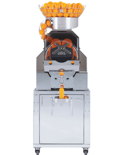 A large, stainless steel commercial juicer with a compartment holding numerous oranges at the top. Several oranges are visible sliding down a chute. A spout in the middle dispenses fresh juice. The Citrus America machine stands on four wheels for mobility, perfect for any citrus delight.