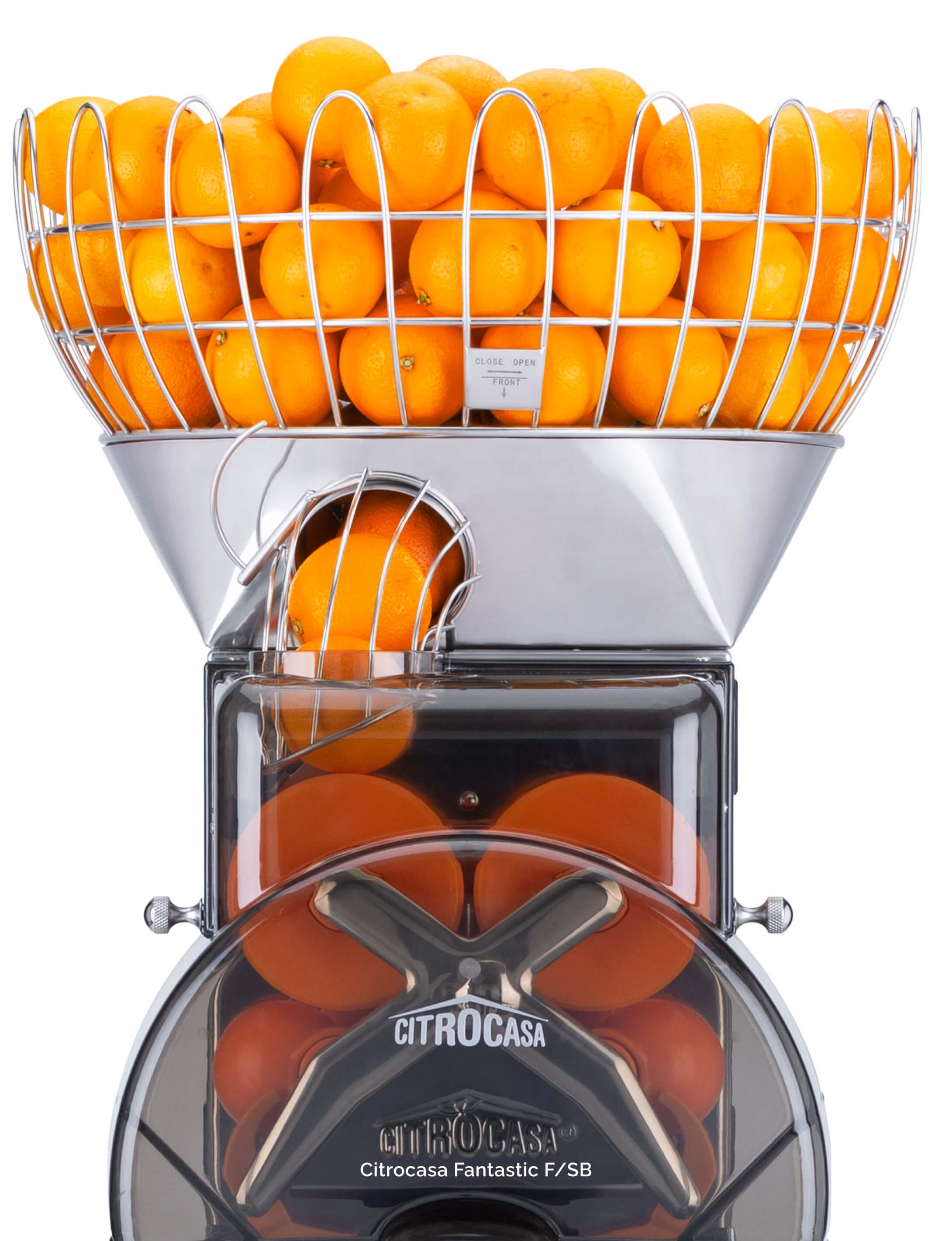 A juicing machine filled with fresh oranges at the top, with more oranges visible inside the machine and in a wire basket above, ready to be juiced. The machine is labeled “Citrocasa Fantastic F/SB.”.